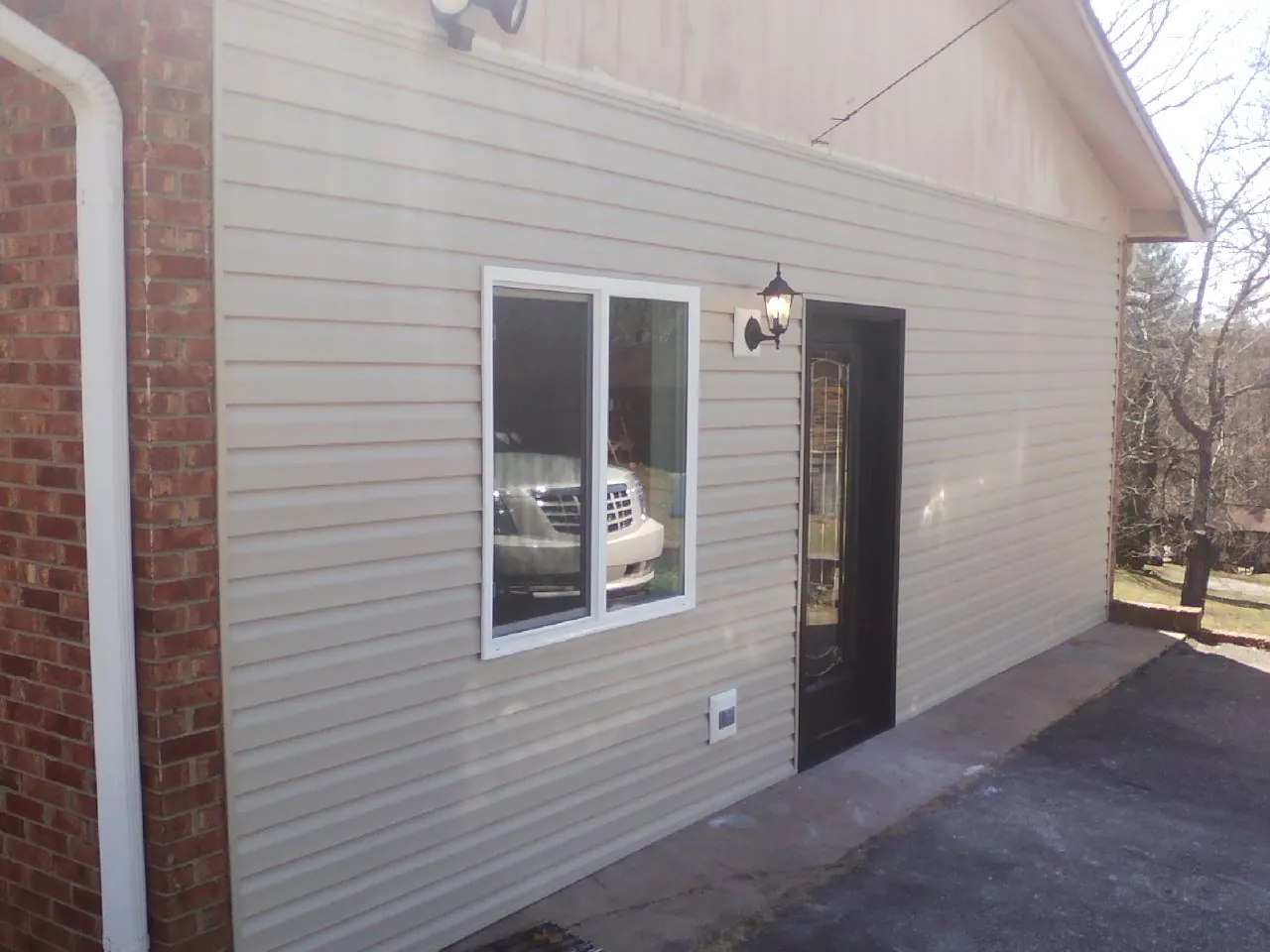 New vinyl siding and entry door on a room addition in Williamsburg