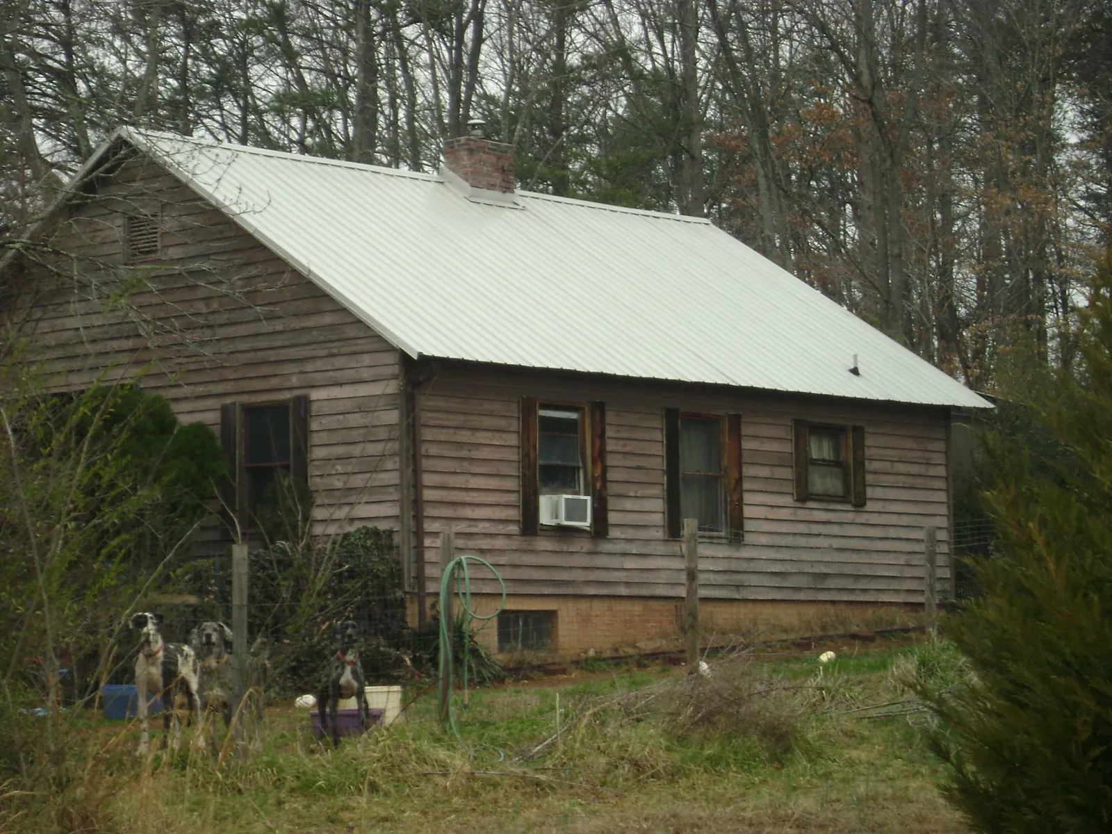 White metal roof on an old wood sided farmhouse, from a Metal Roof Installation job in Williamsburg
